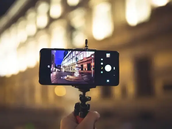 Smartfon na statywie, uchwycił nocną ulicę z fontanną. Dowiedz się, jak ustawić aparat w telefonie, by uzyskać takie ujęcia.